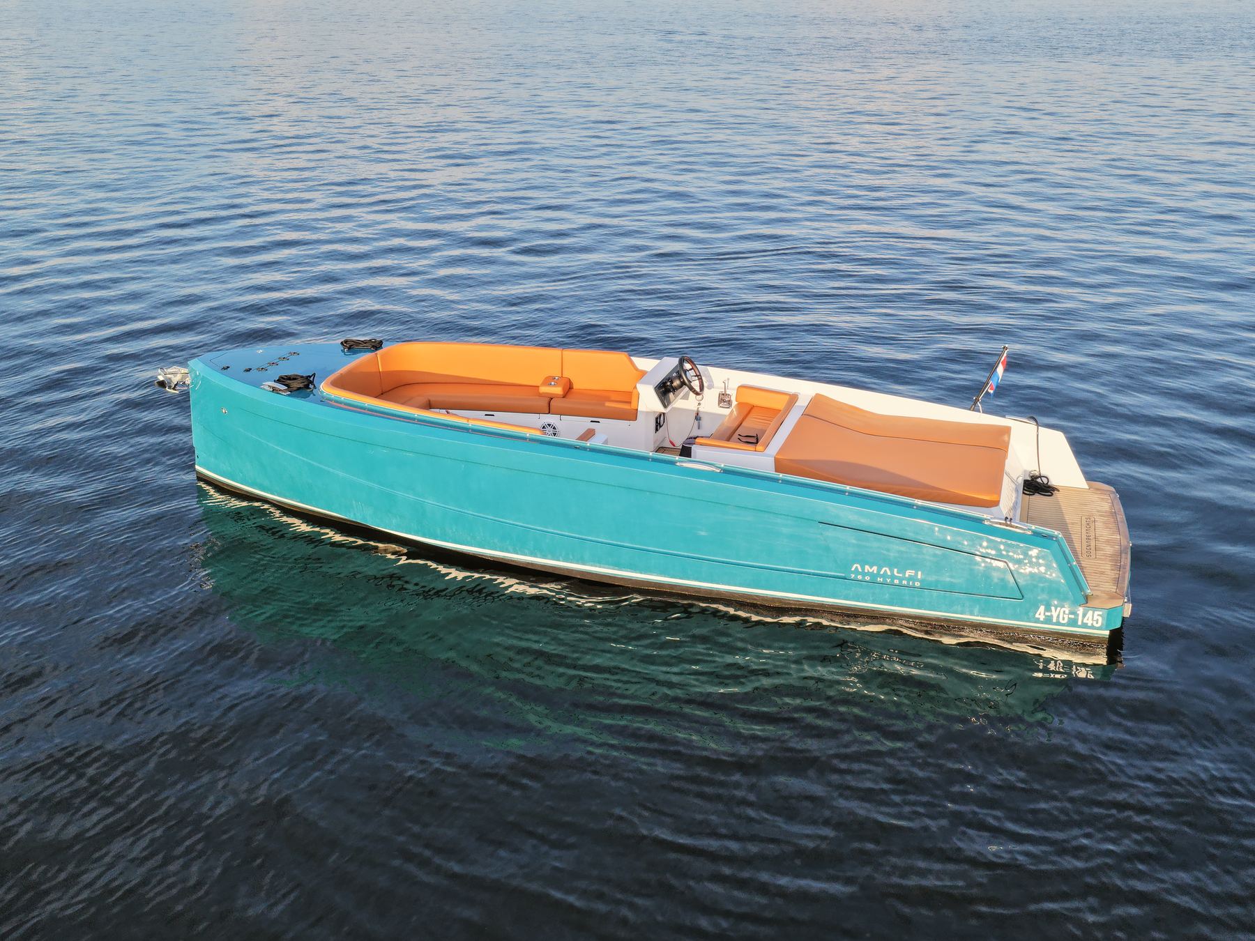 De Sognare Amalfi 760 schuin van achteren op open water in gouden avondlicht, teal aluminium met caramel kussens