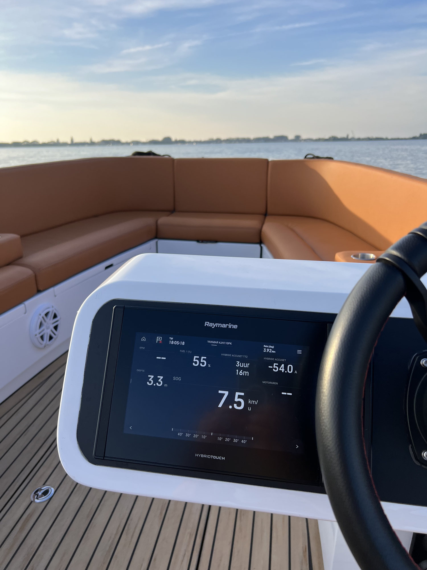 Digitaal Raymarine touchscreen van de Amalfi 760 tijdens het varen, met de caramel zitgroep en de horizon