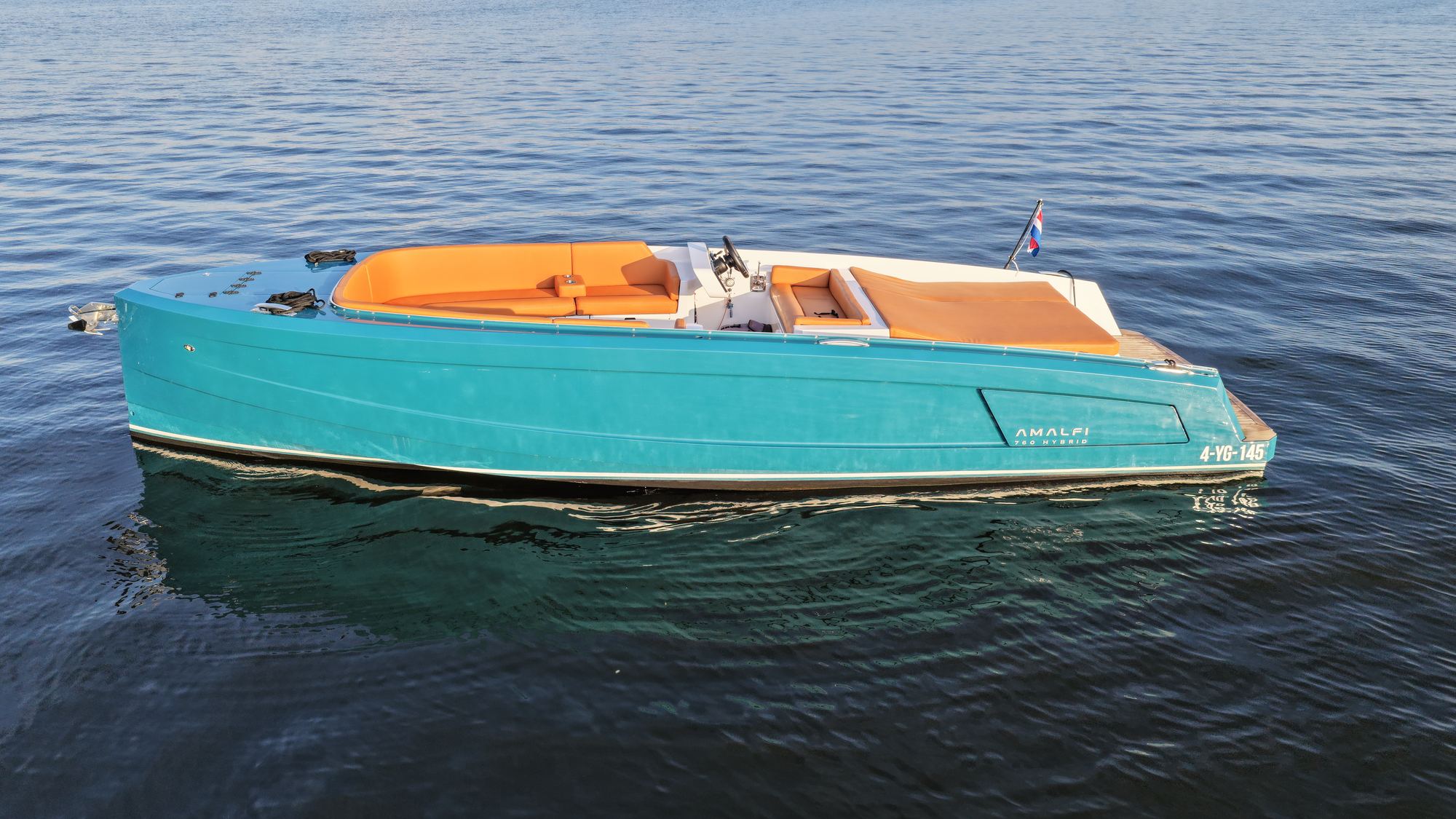 Sognare Amalfi 760 Hybrid zijaanzicht in avondlicht, teal lak en caramel kussens op het water